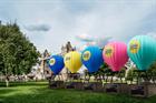 Hot air balloons with Gala Bingo branding lined up on grass next to Tower Bridge in London