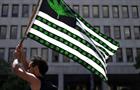 Man waving United States flag redesigned with cannabis plants instead of stars and on the strips