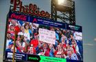 A fan holds up a sign during a kiss cam segment in the game between the Philadelphia Phillies and the Los Angeles Angels at Citizens Bank Park on July 18, 2025 in Philadelphia, Pennsylvania. 