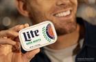 Man holding tin of Miller Lite beer mints