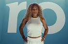 Serena Williams stands in front of the Ro logo