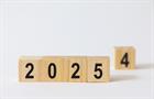 Close-up numbers '2025' and blurred number 4 on wooden blocks