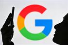 Google 'G' logo in background with silhouette of face looking at smartphone in foreground (©GettyImages)