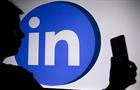 The LinkedIn logo with a person holding a phone in his hand