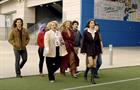Group of people walk onto a sports field