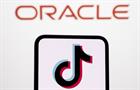 Smart phone displaying TikTok logo with Oracle logo in the back