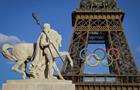The Olympic rings on the Eiffel Tower near the restored statue of Cavalier Arabe in Paris.