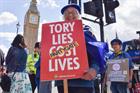 Protesters outside Parliament holding placards saying "Tory Lies Cost Lives" 