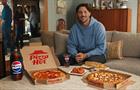 Josh Allen sits on a couch with Pizza Hut food and a Pepsi bottle