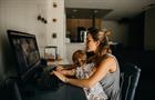 Woman working remotely with child on lap