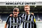 Two men in Newcastle United shirts with their arms round each other