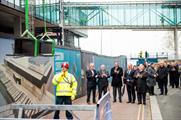 Attendees watch as the beam is lifted