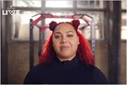Olympic weight lifter Emily Campbell stands in a gym with bright red hair