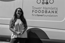 Black and white shot of Bee Pahnke standing in front of a Tower Hamlets Foodbank van