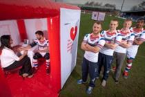 Wakefield rugby players line up outside Public Health England's pop-up health pods