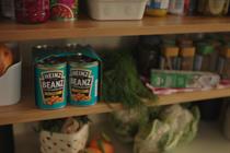 A photo of some larder shelving, with various ingredients, including a multipack of Heinz Baked Beanz