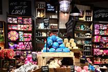A picture of a Lush store, replete with brightly-hued pink, red and other primary coloured cosmetic products