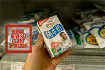 A person holding a small carton of Yili milk