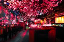 The installation features a series of handmade cherry blossom trees 