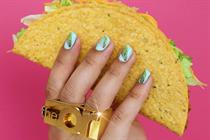 Hand with a gold ring that say theOr holds a hard shell taco