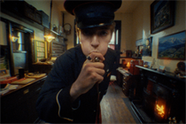 Francis Bourgeois, the viral TikTok star, in a film for Gucci, standing in a train guard's uniform blowing a train whistle