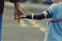 A man holding hands with a child who has a prosthetic arm