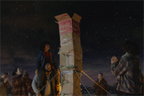 The boy protagonist places a Coca-Cola box on top of the cardboard chimney
