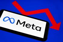 Meta's logo on a phone in front of a downward arrow