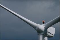 EDF Engineer stands on a wind turbine 