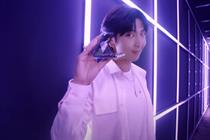 Member of BTS holds Samsung Galaxy Z Flip4 flip phone