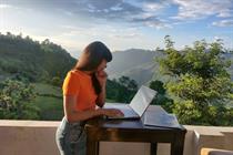 Gen Z woman working remotely in front of a mountains backdrop