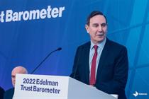 Richard Edelman standing behind a lectern with 2022 Edelman Trust Barometer branding 
