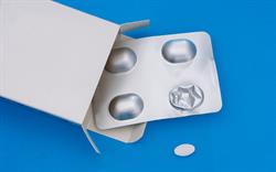 A silver blister pack of four tablets against a blue background, with one white oval tablet removed.