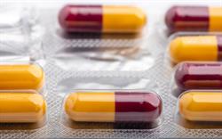 A close up image of half red and half yellow capsules, representing the drug amoxicillin.