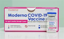 A box of the Moderna COVID-19 vaccine with a vial of the vaccine standing in front of it.
