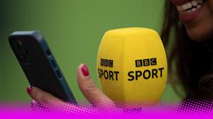 A woman holding a BBC Sport-branded microphone and holding a smartphone
