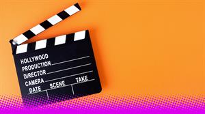 Movie clapper board on orange background with copy space. - stock photo