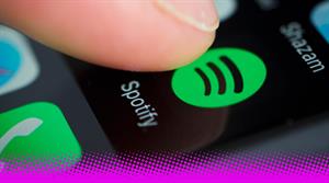 A thumb hovering over the Spotify app on a smartphone