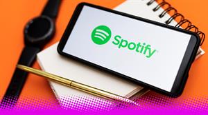 A photograph of a smartphone showing the Spotify logo on top of a notepad