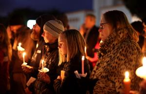 People hold candles during a candlelight vigil for the victims of the mass shooting in Half Moon Bay. (Photo credit: Getty Images).