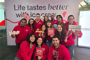 TMICC employees in front of a sign saying 'life tastes better with ice cream'
