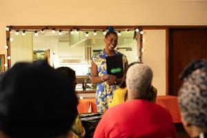 Brenda Edwards standing in front of an audience with a Specsavers clipboard