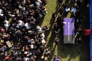 People carrying a large casket