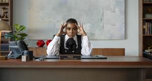Taraji P. Henson sits behind a desk with a name plate reading 