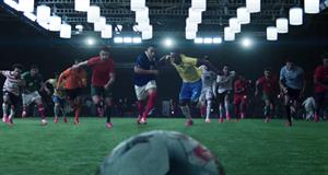 A group of footballers run after a football