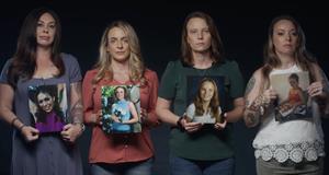 Four women hold pictures of survivors of abuse at the hands of sex trafficker Jeffrey Epstein