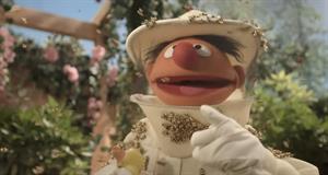The Sesame Street character Ernie wearing a beekeeper suit covered in bees