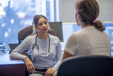 Female GP in consultation with a young woman