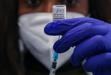 An NHS vaccinator draws the Pfizer COVID-19 vaccine