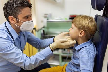 全科医生正在检查一个小男孩的喉咙